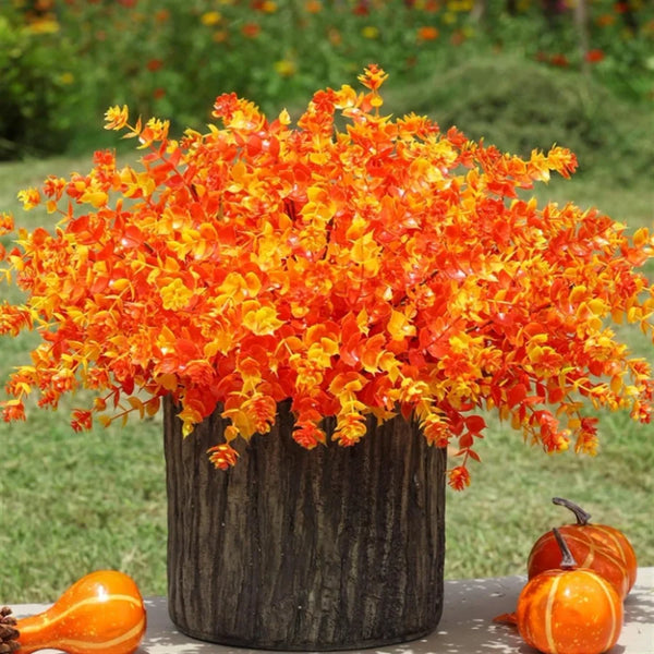 A vibrant arrangement of orange artificial shrubs used for seasonal decor.