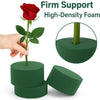A hand holds a red rose stem emerging from a green high-density foam block, with additional blocks shown.