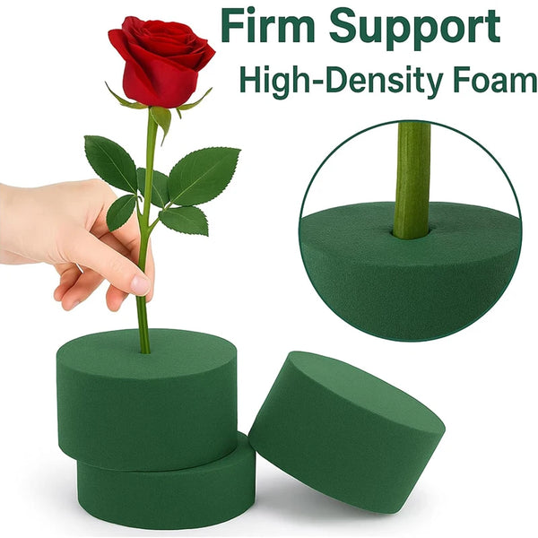 A hand holds a red rose stem emerging from a green high-density foam block, with additional blocks shown.