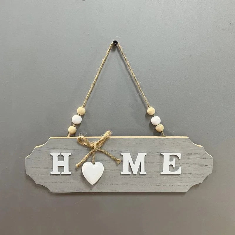 Rustic wooden door welcome sign with the word HOME cut into the wood and suspended by twine
