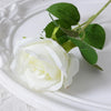 White velvet artificial rose with green leaves on a white plate