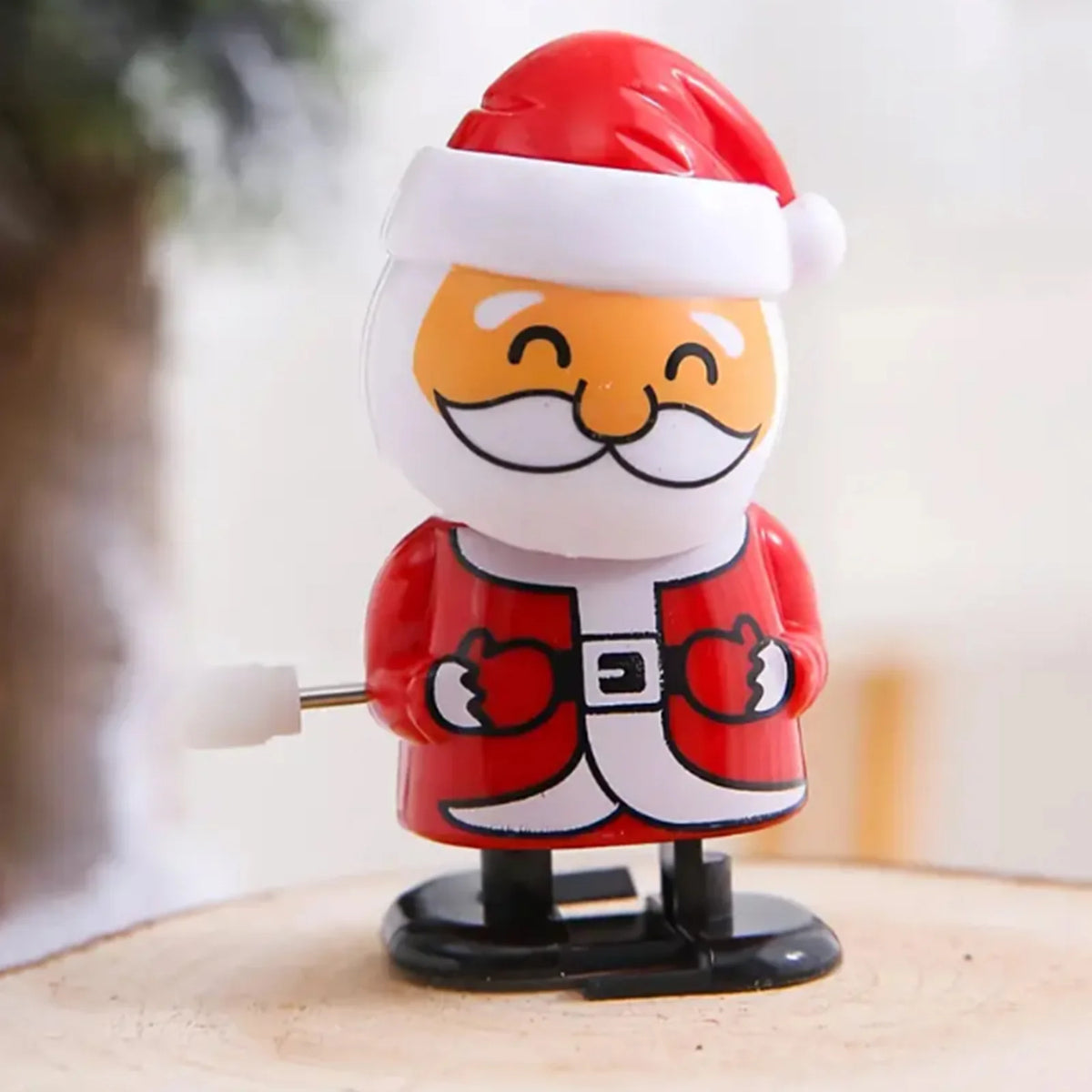 A festive wind-up figurine of Santa Claus with a red hat and beard.