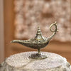 Brûleur d'encens en métal antique avec des détails complexes, posé sur une surface de pierre.