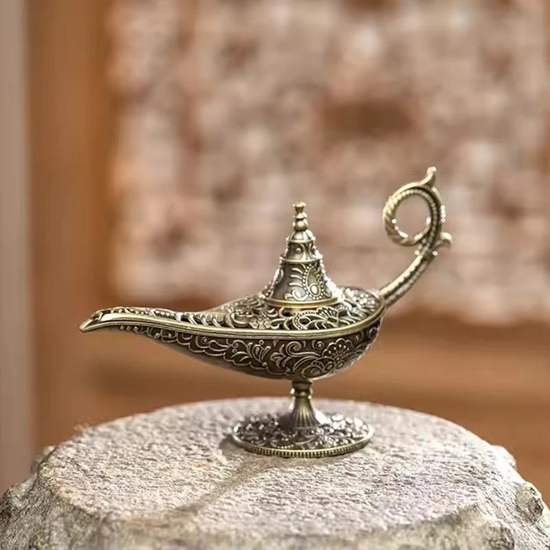 Brûleur d'encens en métal antique avec des détails complexes, posé sur une surface de pierre.