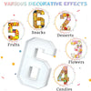 A white cardboard number six with decorative elements showing fruits, snacks, desserts, flowers, and candies.