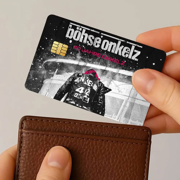 Eine Hand hält einen wiederverwendbaren Schutzaufkleber für Kreditkarten mit dem Text böhse onkelz auf schwarzem Hintergrund.