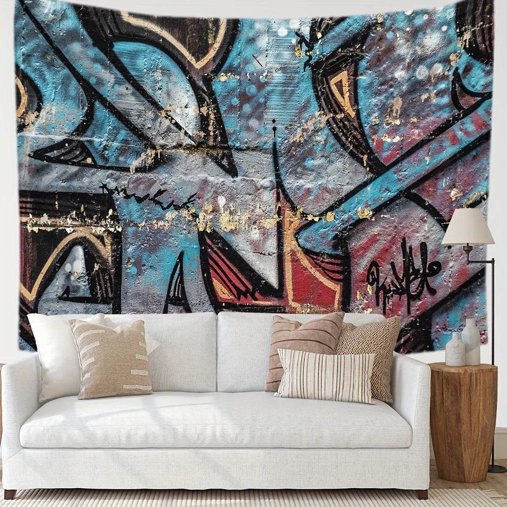 A modern living room featuring a white sofa adorned with neutral pillows and a large urban graffiti tapestry hanging on the w