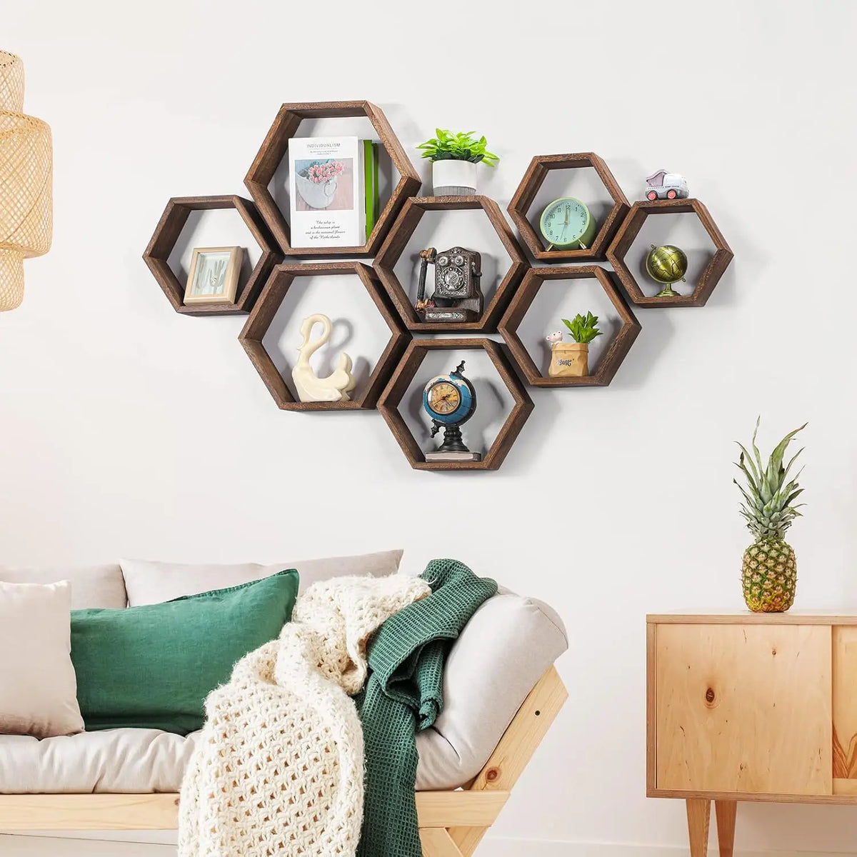 A set of four wooden hexagon floating shelves displaying various small decorative items like clocks and plants.