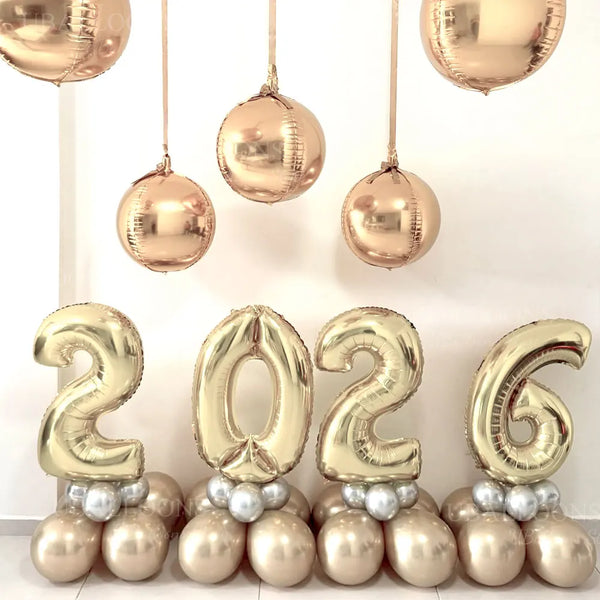 A display of large champagne gold foil number balloons spelling out 2026 for party decor.