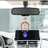 An elephant charm amulet hanging from a horseshoe on a wall display inside a car
