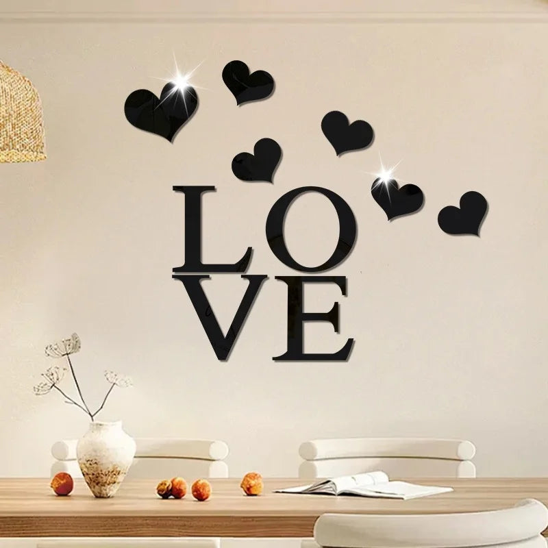 Black acrylic heart wall stickers spelling out LOVE with a mirror finish on a light wall.