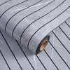 Roll of self-adhesive 3D wood grain wall panels showing a gray marble pattern and dark green edge.
