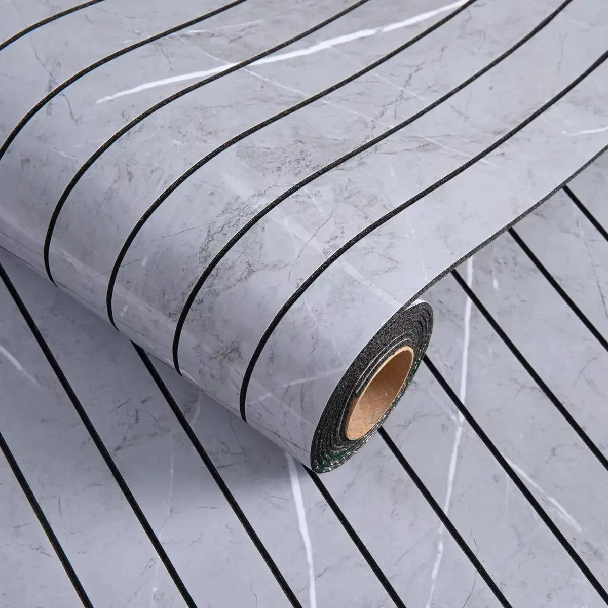Roll of self-adhesive 3D wood grain wall panels showing a gray marble pattern and dark green edge.