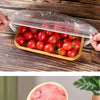Reusable plastic food wrap covers with elastic edges shown being used to wrap fresh strawberries and tomatoes.