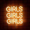 A glowing neon sign spelling out GIRLS in a rounded font against a dark, grid-patterned background.