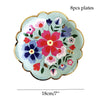 Eight decorative floral disposable plates in shades of pink, purple, and green on a light teal background.