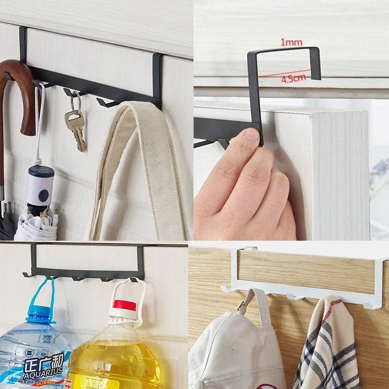 A close-up of a black iron door and wall organizer rack with hooks, showing installation on a white cabinet and wood surface.