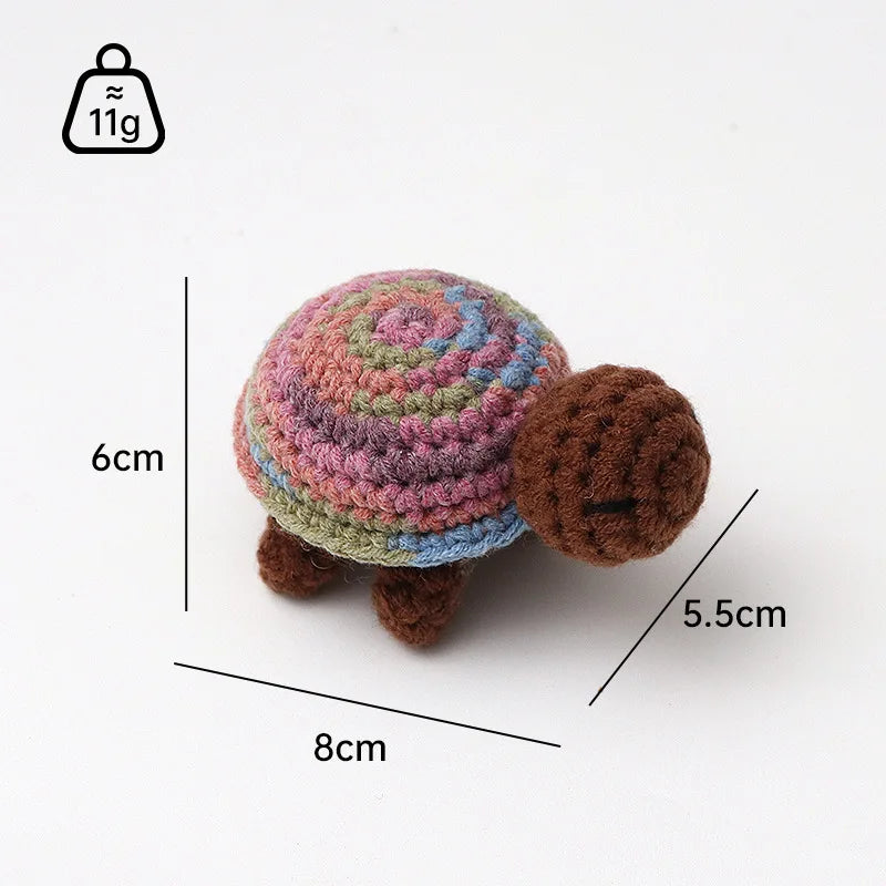 A handmade crocheted turtle plush toy with a textured shell and brown body, shown against a white background.