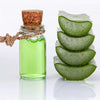 A glass bottle filled with green liquid and a cork stopper, next to several sliced green leaves.