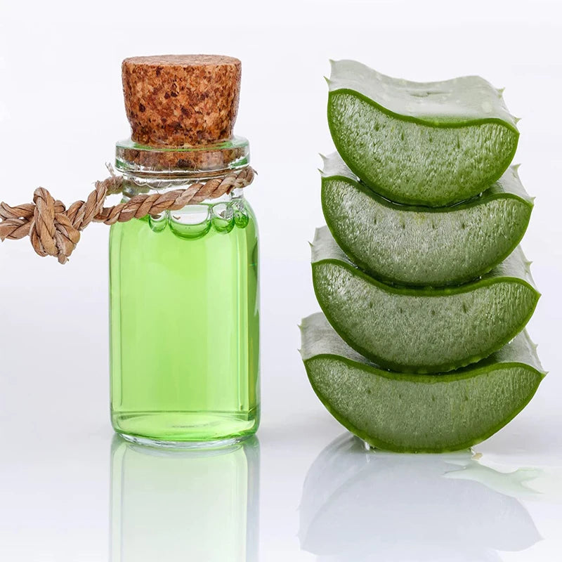 A glass bottle filled with green liquid and a cork stopper, next to several sliced green leaves.