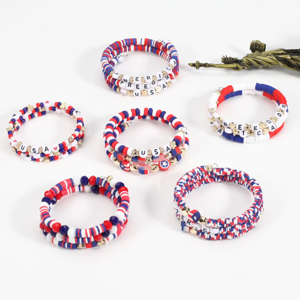 A collection of patriotic American flag beaded stretch bracelets in red, white, and blue colors.