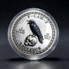 A silver challenge coin featuring a crow perched on a skull with the text Last Fuck