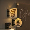 A magnetic fridge decor featuring a coffee cup design with a soft glow and text encouraging more coffee.