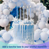 A light blue frosted birthday cake decorated with white icing drips and silver candles on a white background.