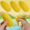 A set of yellow squishy food-shaped stress balls, including a corn and a squash, being held by a hand.