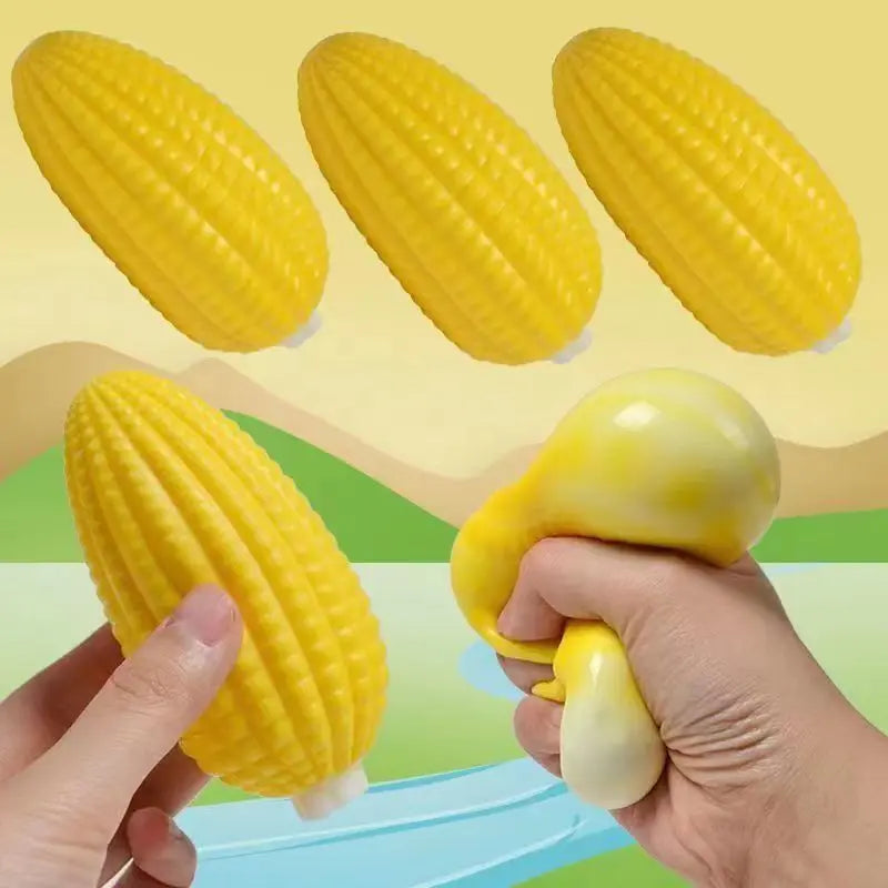 A set of yellow squishy food-shaped stress balls, including a corn and a squash, being held by a hand.