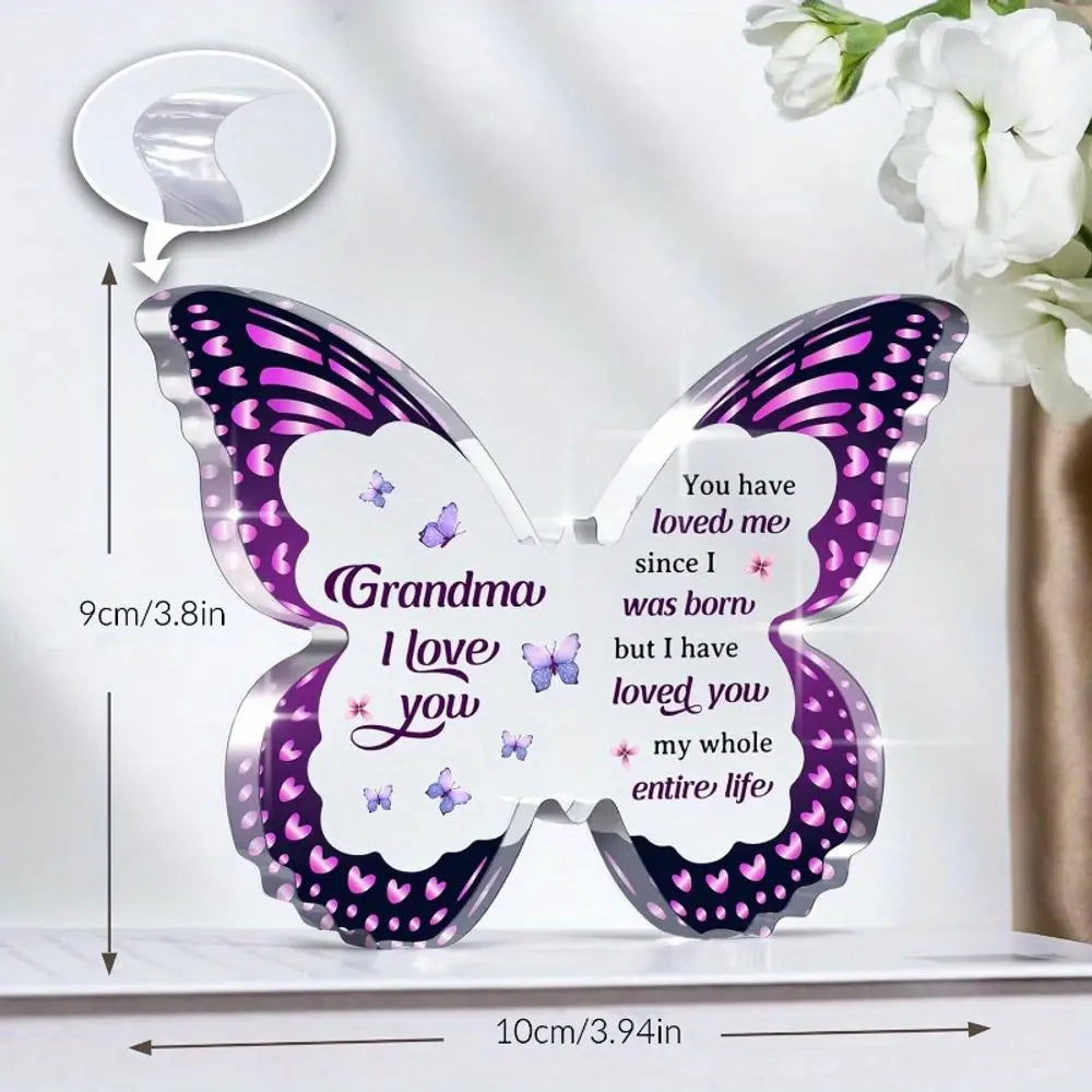 A purple and silver acrylic butterfly keepsake with a message inside, featuring the text Grandma I love you.