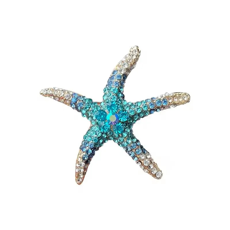 A vintage marine life brooch pin set shaped like a starfish with blue and clear stones.