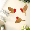 A set of three vintage wooden bird wall decorations in shades of orange and red against a light background.