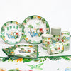 A green and white dinosaur party disposable tableware set featuring plates, cups, and a banner.