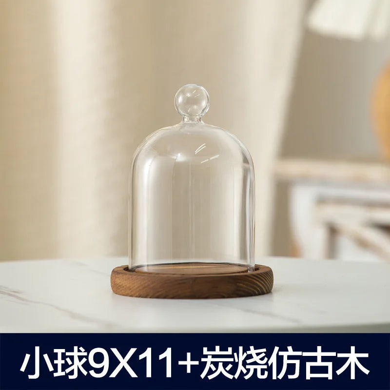 Glass aromatherapy candle holder with a clear dome and a wooden base