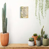 A framed canvas print featuring Psalm 91 scripture in a rustic design displayed on a white wall.
