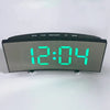 A digital LED alarm clock displaying 12:04 with mode buttons and a temperature display.