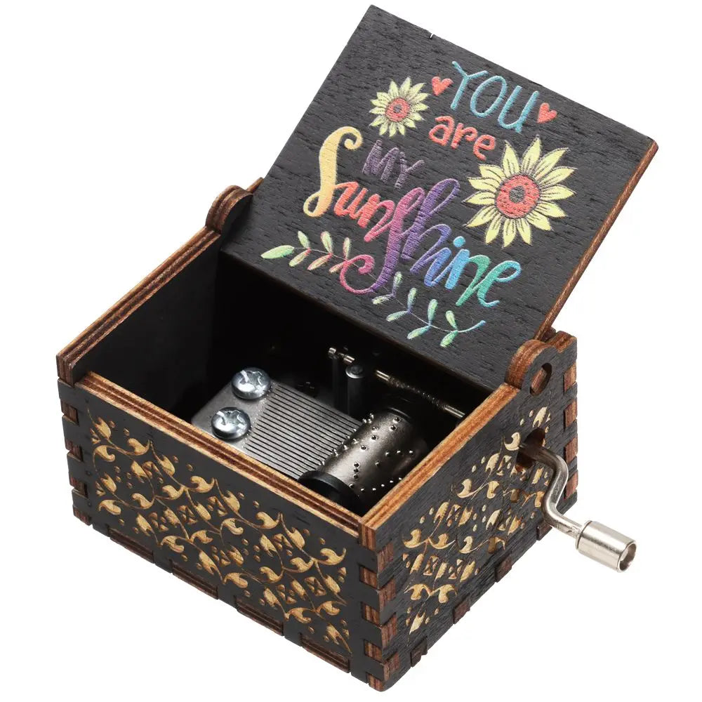 A vintage hand-cranked wooden music box with an open lid featuring the text You are my sunshine.