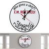 Weiße Wanduhr mit schwarzem Zifferblatt, die Zeit anzeigt und den Text "Who gives a shit I'm retired" trägt