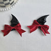 A pair of black devil horn and bat wing hair clips in deep red satin ribbon.