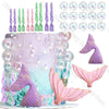 A mermaid-themed cake decorated with purple and pink sea creature toppers, including fish and tail shapes.