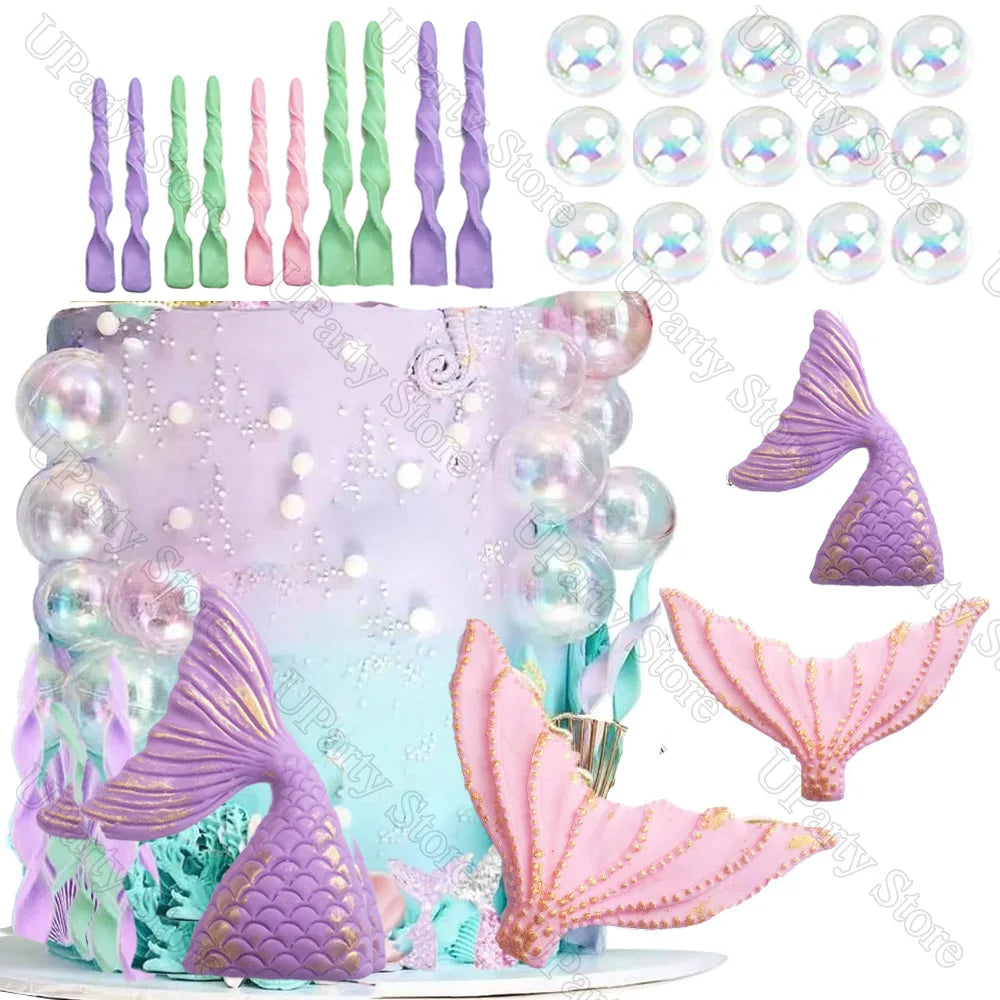 A mermaid-themed cake decorated with purple and pink sea creature toppers, including fish and tail shapes.