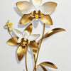 Una flor de orquídea dorada y blanca en un tallo esbelto contra un fondo claro.