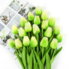 A bouquet of artificial lime green tulips with green stems and leaves.