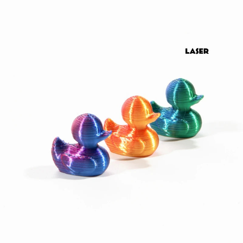 Drei 3D-gedruckte Mini-Entenfiguren in Blau, Orange und Türkis vor weißem Hintergrund.