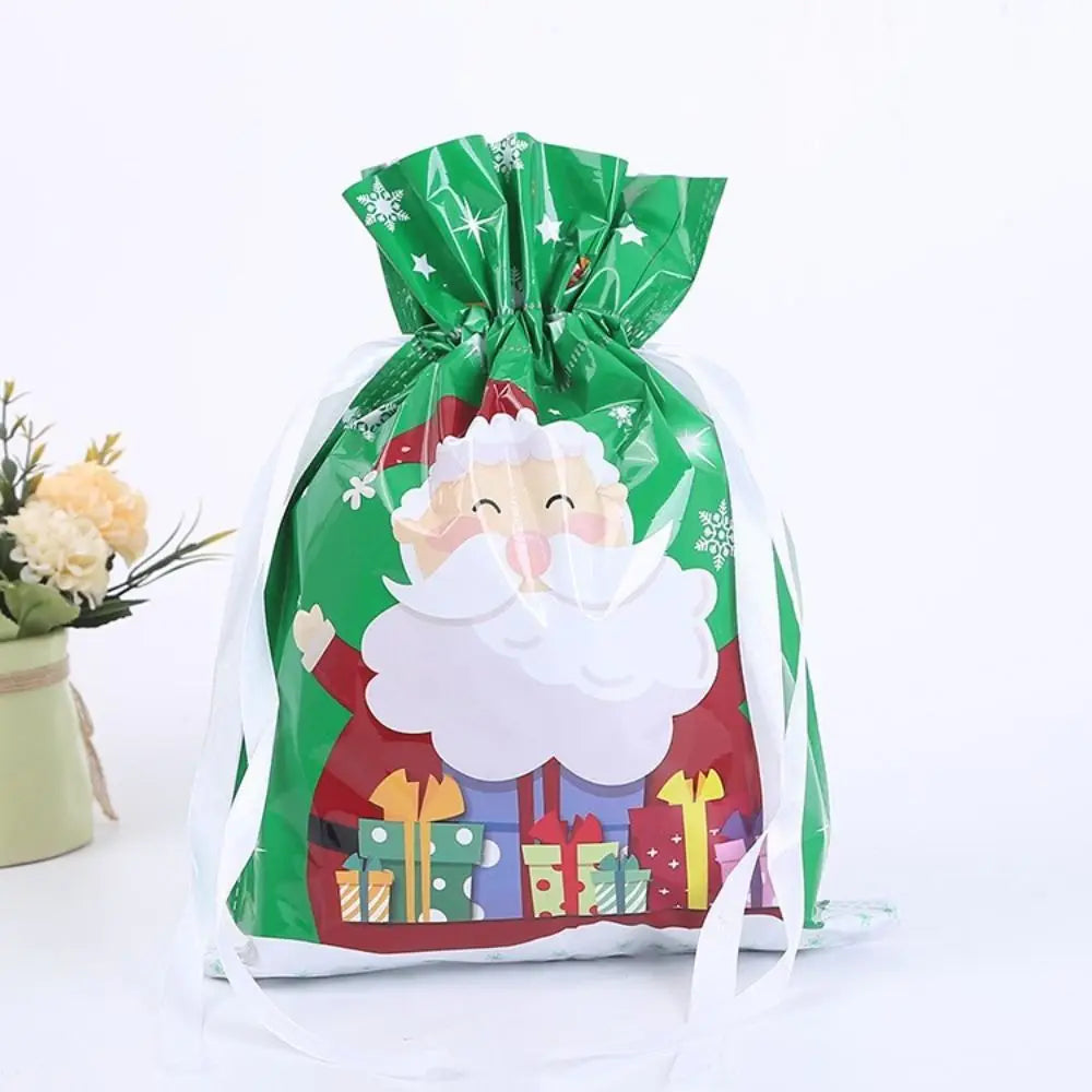 A festive green drawstring gift bag featuring Santa and snowman designs with a white fluffy beard.