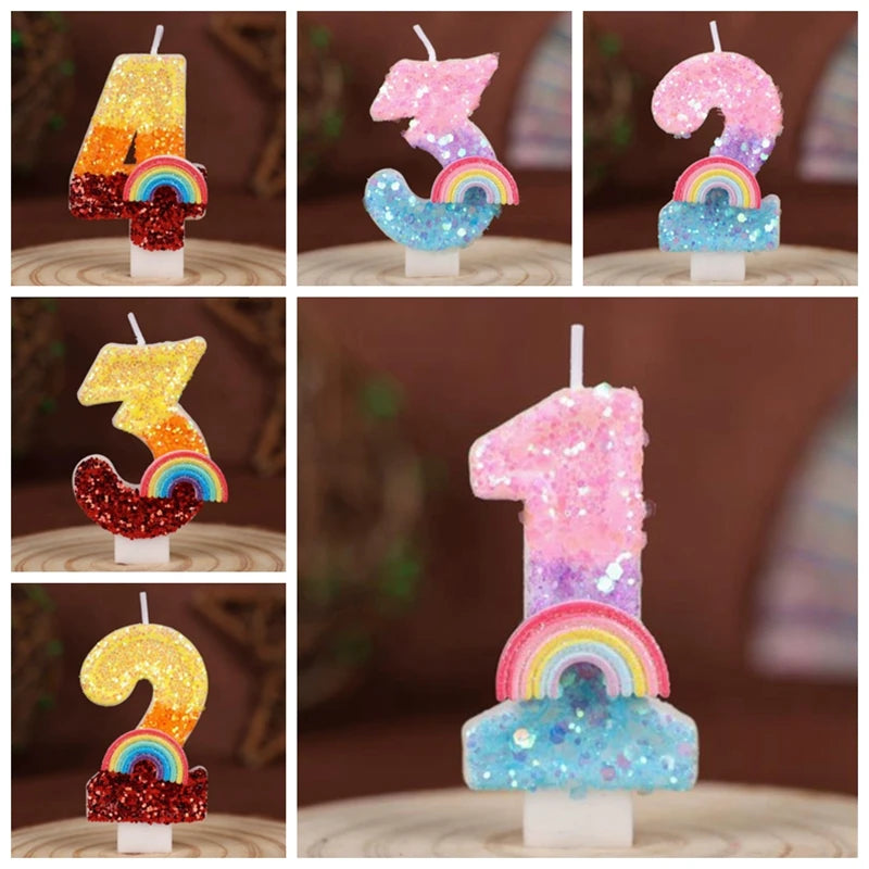 A set of rainbow sequined number candles shaped like 1, 3, 5, and 7 displayed on a wooden surface.