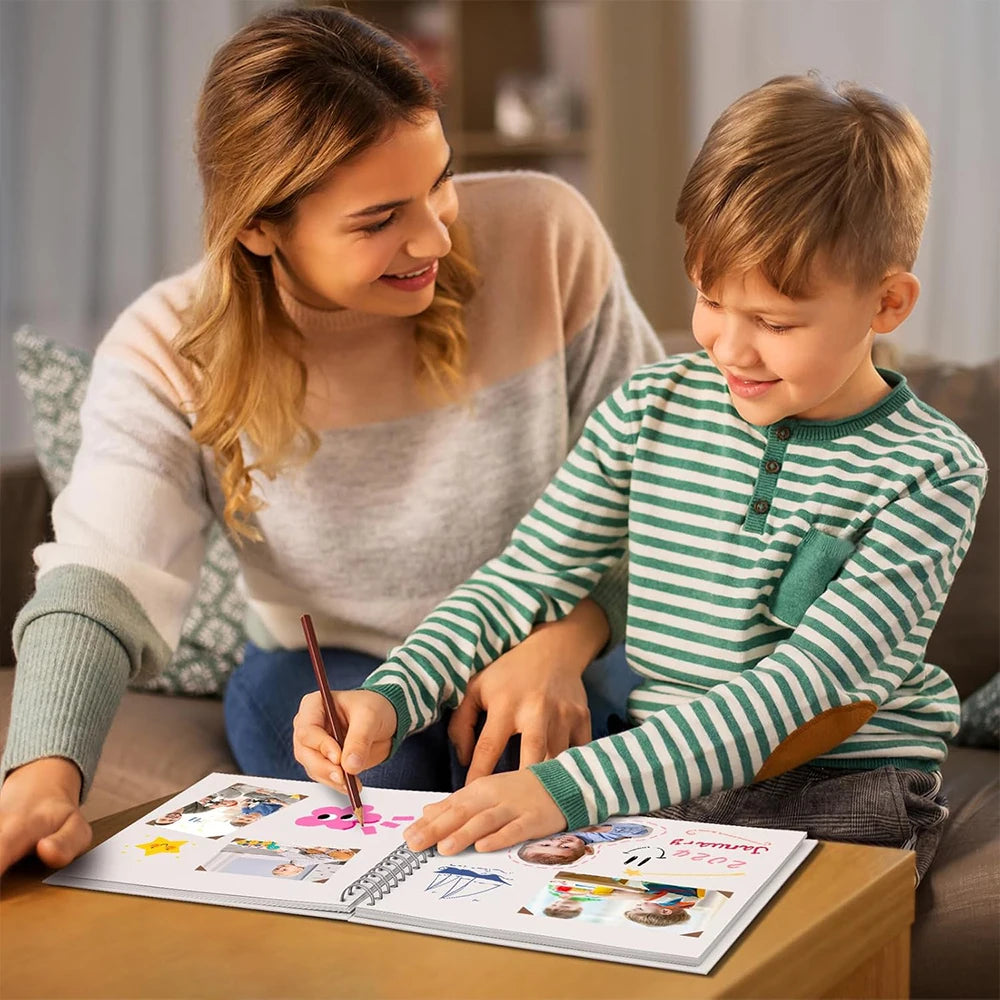 A mother and son are looking at a spiral-bound kraft paper scrapbook for DIY memory keeping.