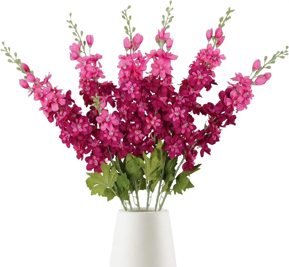 Un bouquet de fleurs artificielles de delphinium roses et magenta dans un vase blanc.