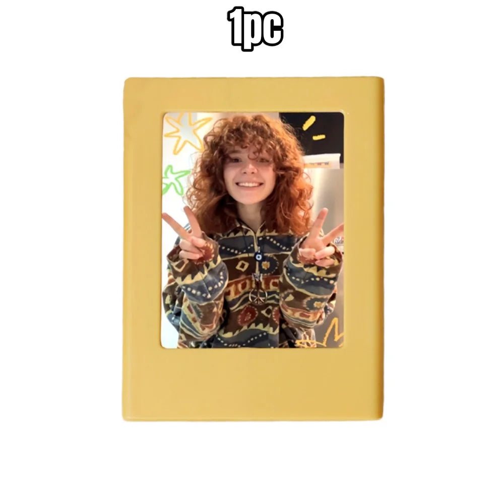 A yellow retro magnetic photo frame displaying a person with curly red hair making a peace sign.